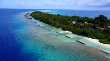 Mavi okyanus ve beyaz kum arka planında sakin sahil seyahatlerinin insansız hava aracı turizmi
