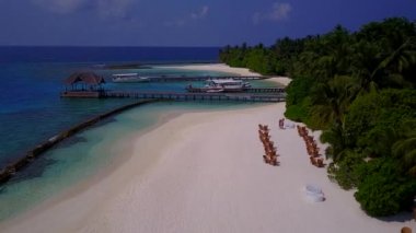 Blue Lagoon 'un temiz kum arka planına sahip sakin sahil tatilinin insansız hava aracı yolculuğu.