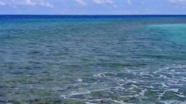 Mavi yeşil deniz ve temiz kumlu zemin ile tropikal sahil maceralarının insansız hava aracı manzarası