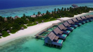 Mavi deniz ve beyaz kumlu arka planda huzurlu sahil yolculuğunun insansız hava aracı soyutlaması