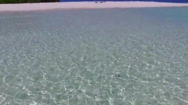 Şeffaf deniz manzaralı güzel sahil tatili manzarası ve temiz kumlu arka plan.