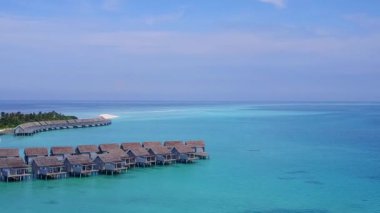 Parlak kumlu arka planlı mavi deniz kıyısında egzotik sahil tatilinin hava aracı manzarası