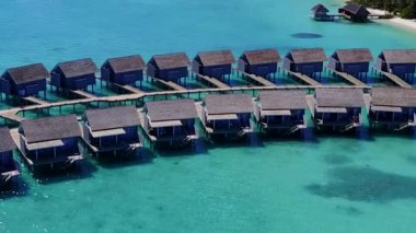 Turkuaz deniz ve parlak kum arka planının rahatlatıcı sahil macerasının hava aracı dokusu