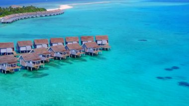 Şeffaf lagünün ve beyaz kum arka planının rahatlatıcı sahil gezisinin insansız hava aracı manzarası