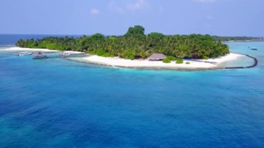 Temiz okyanus ve beyaz kum arka planındaki sakin sahil saatinin insansız hava aracı görüntüsü