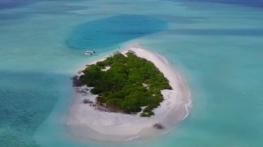 Açık okyanus ve beyaz kum arka planındaki deniz turistlerinin insansız hava aracı.