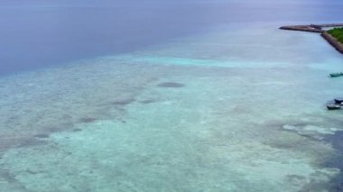 Deniz kıyısı sahil saatinin İHA hava dokusu beyaz kumlu arka planda berrak bir lagün tarafından