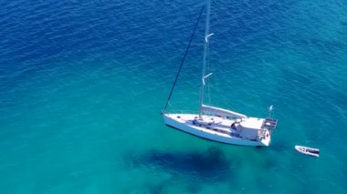 Gökyüzü manzaralı turizm turizmi. Beyaz kumlu arka planlı, mavi deniz kıyısında cennet gibi bir sahil macerası.