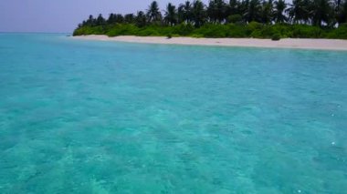 İHA gökyüzü bembeyaz kum arka planlı mavi sularda cennet gibi turistik bir sahil yaşam tarzı.