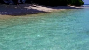 Berrak sularda, beyaz kumlu arka planda, cennet gibi sahil tatilinin hava yolculuğu.