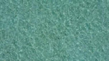 Cennet adasının hava aracı gökyüzü beyaz kum zeminli mavi okyanus tarafından kırılıyor.