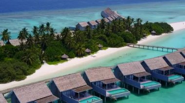 Mavi okyanus kıyısında beyaz kumlu bir sahil gezisinin insansız hava aracı görüntüsü