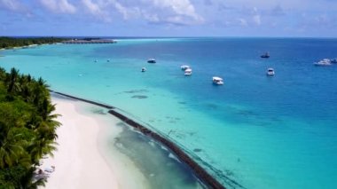 Deniz kıyılarının insansız hava aracı sahili beyaz kum zeminli mavi lagün tarafından yıkılıyor.