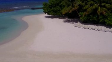 Mavi yeşil deniz kıyısında, beyaz kumlu arka planda sakin bir turist plajı tatili.