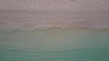 Mavi su ve beyaz kumlu arka planda cennet manzaralı deniz manzaralı insansız hava aracı.