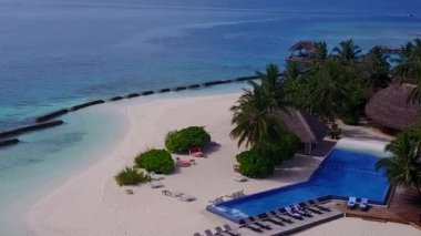 Mavi deniz kıyısındaki temiz kum arka planlı lüks sahil maceralarının insansız hava aracı soyutlaması.