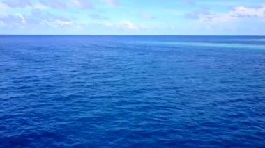 Mavi su ve beyaz kumlu arka planda güzel sahil sahili saatinin gökyüzü.