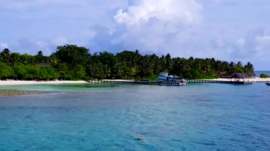 Sahil sahil yolculuğunun insansız hava aracı manzarası şeffaf deniz kenarında, temiz kum arka planda.