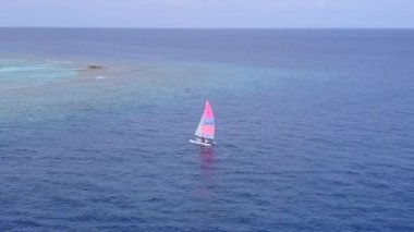Cennet manzaralı hava aracı sahili beyaz kumlu arka planlı turkuaz deniz tarafından yıkılıyor.