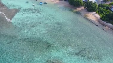 Günbatımından önce mavi yeşil deniz ve beyaz kum arka planıyla turist plajı seyahatinin geniş açılı doğası