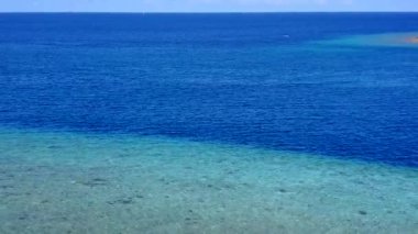 Güneş batmadan önce mavi deniz ve beyaz kum arka planında tropikal sahil yaşam tarzının ılık gökyüzü