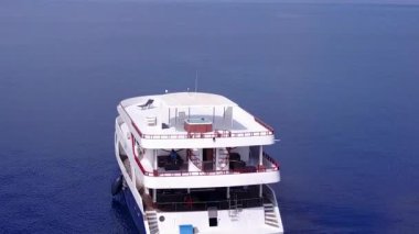 Deniz kıyısı sahil gezisi için beyaz kum arka planlı mavi okyanus üzerinden yapılan insansız hava aracı yolculuğu.