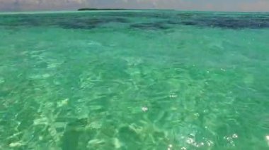 Güneş doğduktan sonra beyaz kumlu arka planda turkuaz deniz kenarında sakin bir turistik plaj tatili.