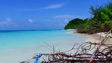 Lüks sahil şeridinin yaz manzarası güneş doğduktan sonra beyaz kumlu arka planlı mavi lagünün yanında kırılıyor.