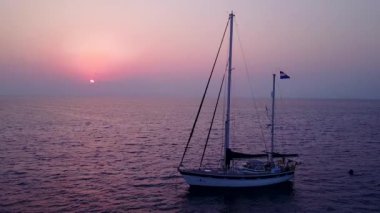 Mavi okyanus kıyısındaki sakin sahil manzarası ve güneş doğduktan sonra beyaz kumlu arka plan.