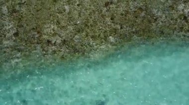 Mavi göl kenarında egzotik sahil tatilinin güneşli manzarası ve güneş ışığında beyaz kum arka planı