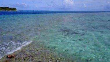 Plaj maceralarının romantik manzarası şeffaf deniz kenarında, kumsalın yanında beyaz kum arka planda.