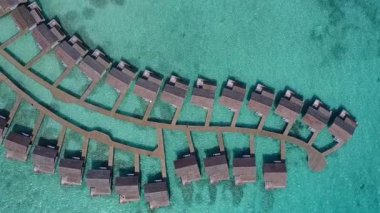Lüks turist plajlarının gündüz soyutlanması mavi göl kıyısında ve dalgaların yakınındaki beyaz kum arka planında gerçekleşiyor.