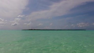 Resifin yakınındaki beyaz kum arka planlı mavi lagünün rahatlatıcı plaj macerasının boş manzarası.