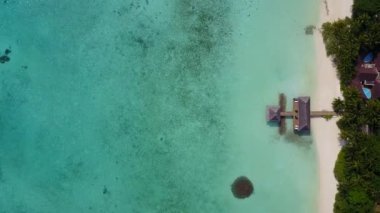 Mavi lagün ve resifin yakınındaki beyaz kum arka planının oluşturduğu mükemmel sahil macerasının yaz doğası.