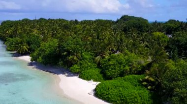 Turkuvaz suyu ve tatil köyü yakınlarındaki parlak kumlu arka planla tropikal tatil yerinin boş doğası.