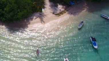 Mavi göl kıyısında güneşli sahil turizmi ve gün batımından önce beyaz kum arka planı.