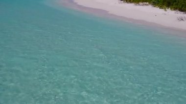 Mavi lagünün beyaz kum arka planında sakin bir tatil köyünün hava aracı dokusu.