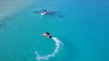 Mavi okyanus kıyısındaki sakin sahil tatilinin uzay dokusunu kopyala ve sörfün yanındaki beyaz kum arka planını.