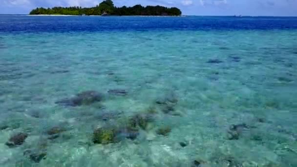 Nahaufnahme des entspannten Inselstrandlebens durch die blaue Lagune und den weißen Sandhintergrund vor Sonnenuntergang — Stockvideo