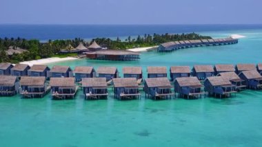 Mavi yeşil deniz kıyısında beyaz kum arka planlı sakin sahil turizmi.