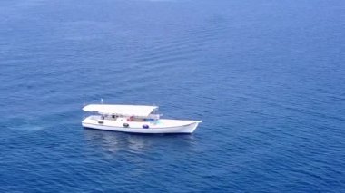 Güneş doğduktan sonra parlak kumlu arka planla berrak okyanus kıyısında güneşli turistik plaj gezisi.