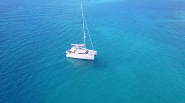 Su mavi suyu ve tatil köyü yakınlarındaki beyaz kumlu arka planda cennet gibi turistik bir sahil yolculuğu.
