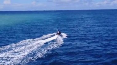 Turkuaz denizinin kumsal kenarındaki egzotik sahil yolculuğunun güneşli dokusu.