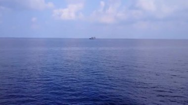 Sahil kenarındaki beyaz kumlu arka planda şeffaf okyanus tarafından deniz lagününün ılık turizmi