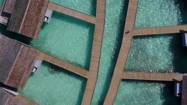 Mavi okyanus kıyısında dalgaların yanında beyaz kum arka planıyla huzurlu deniz kıyısında geniş açılı bir yolculuk.