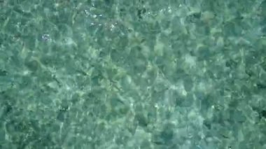 Gün batımından önce şeffaf su ve beyaz kum arka planındaki deniz turistlerinin uzay manzarasını kopyala