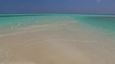 Sığ okyanus ve tatil köyü yakınlarındaki temiz kum arkaplanı yakınlarındaki dinlendirici körfez sahil seyahatinin gökyüzünü kapatın.