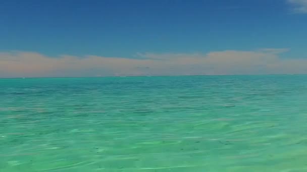 波の近くに明るい砂浜の背景を持つターコイズブルーのラグーンによる海洋ビーチ旅行の空の風景 — ストック動画