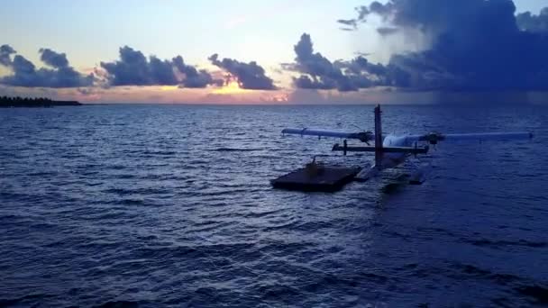 Сонячний морський плацдарм ідилічного берегового відпочинку синім зеленим океаном і білим піщаним фоном біля піщаниці. — стокове відео