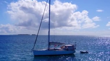 Mavi deniz kıyısında beyaz kumlu arka planda, cennet gibi sahil yolculuğunun insansız hava aracı deniz manzarası.
